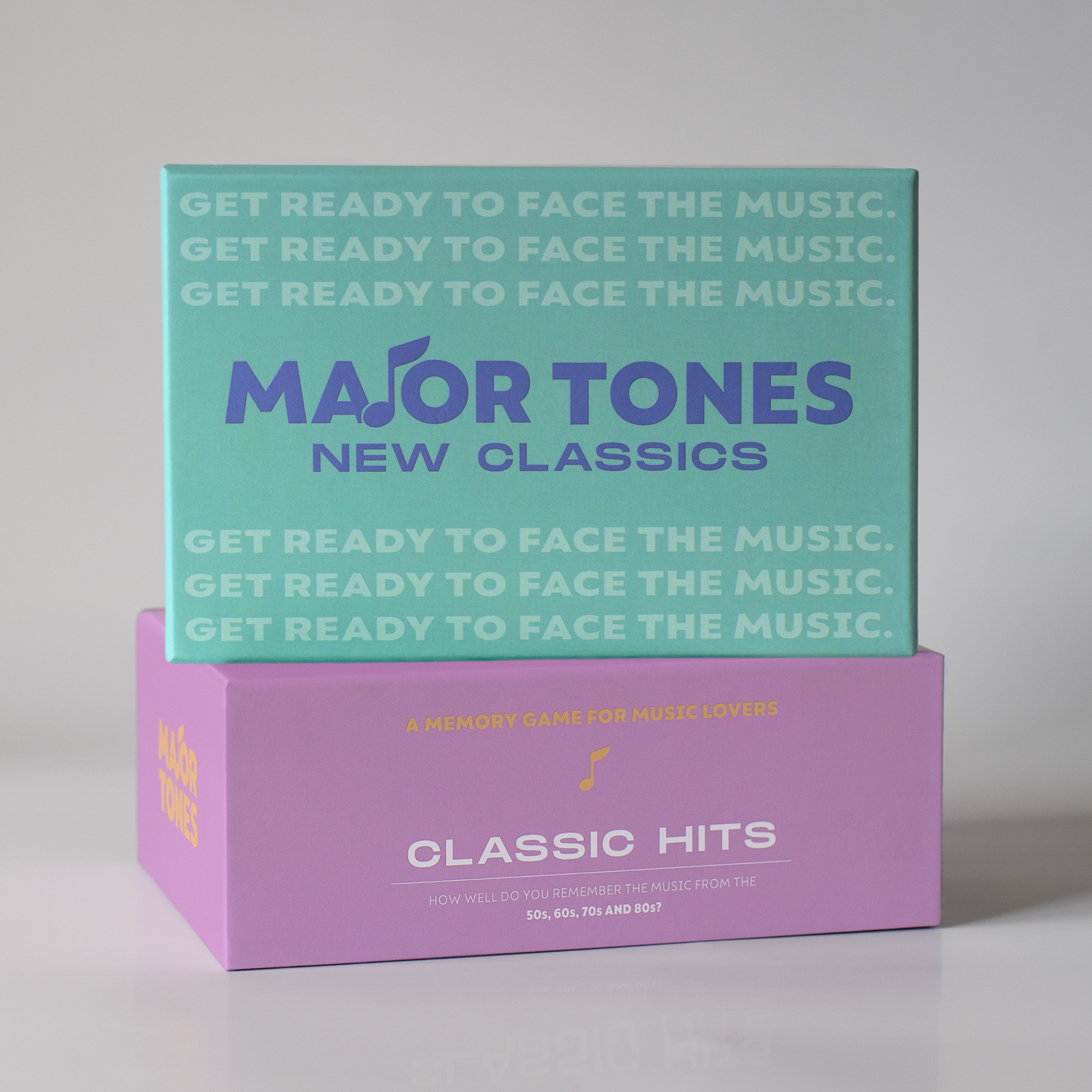 Green New Classics Major Tones box packaging face on, sitting on top of purple Classic hits deck packaging